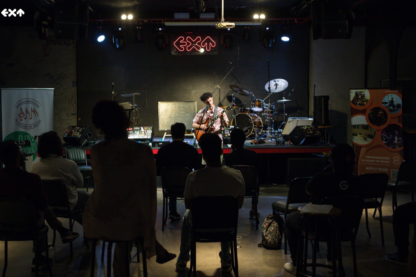 The room during the set, an audience seated in front of the low club stage